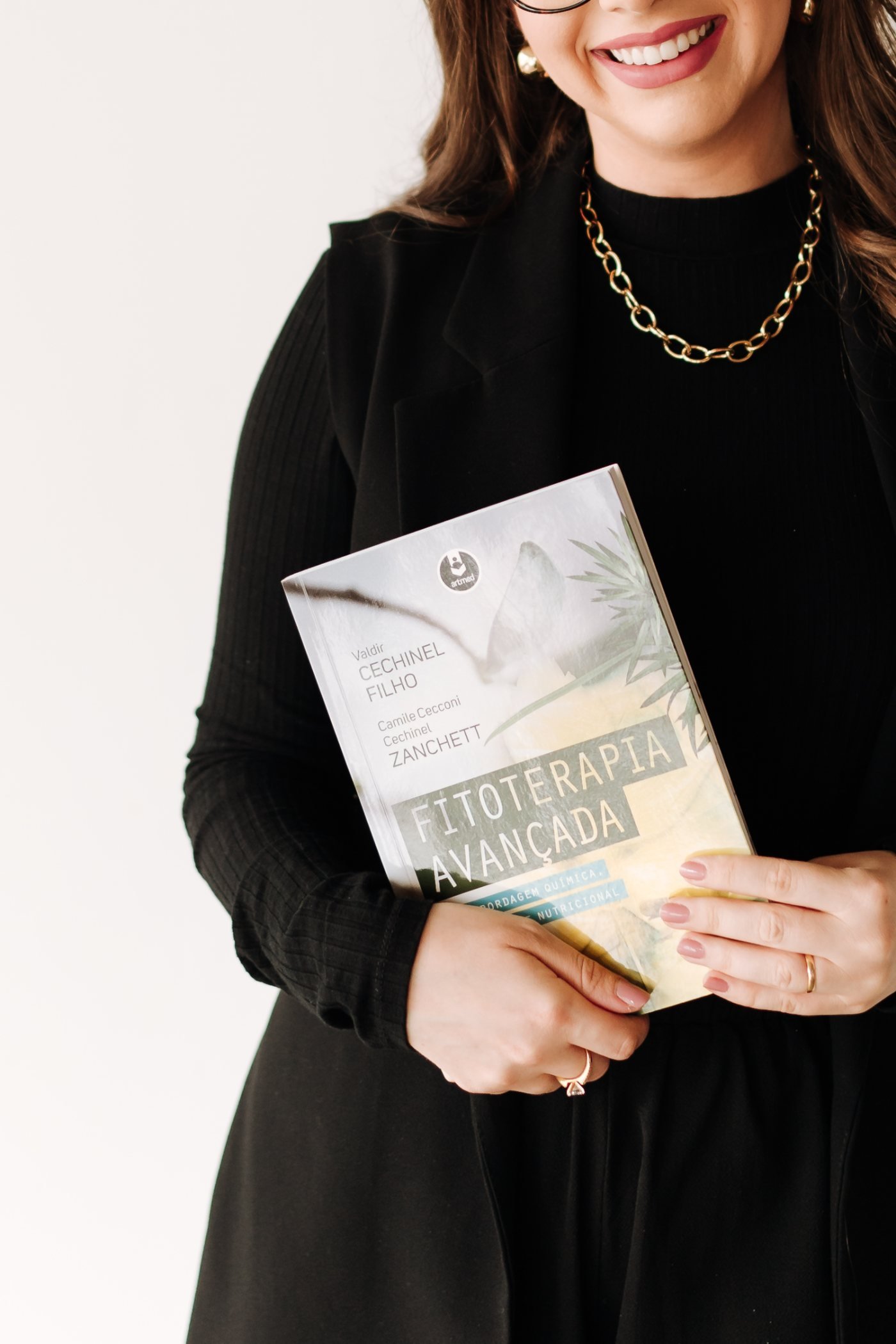 Camile Zanchett segurando o livro Fitoterapia Avançada.